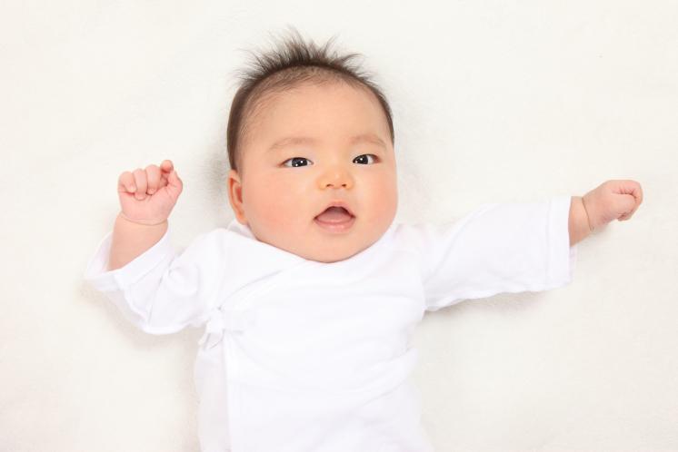 2 month old baby in a white outfit with white background