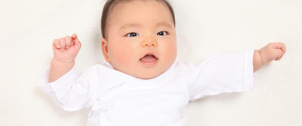 2 month old baby in a white outfit with white background