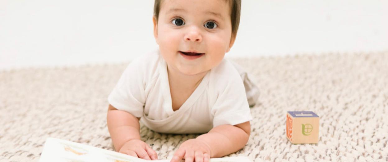 8, 9, 10 month old playing on the floor with a book and a block, 8-10 month sleep regression