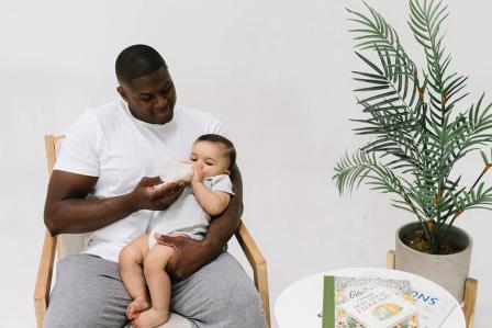 Dad rocking baby while offering a feeding before bedtime
