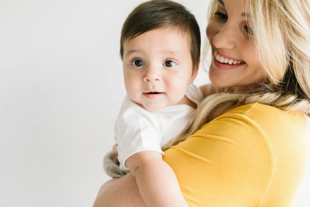 Mom looking at baby in her arms and baby looking away as they prepare for babysitter