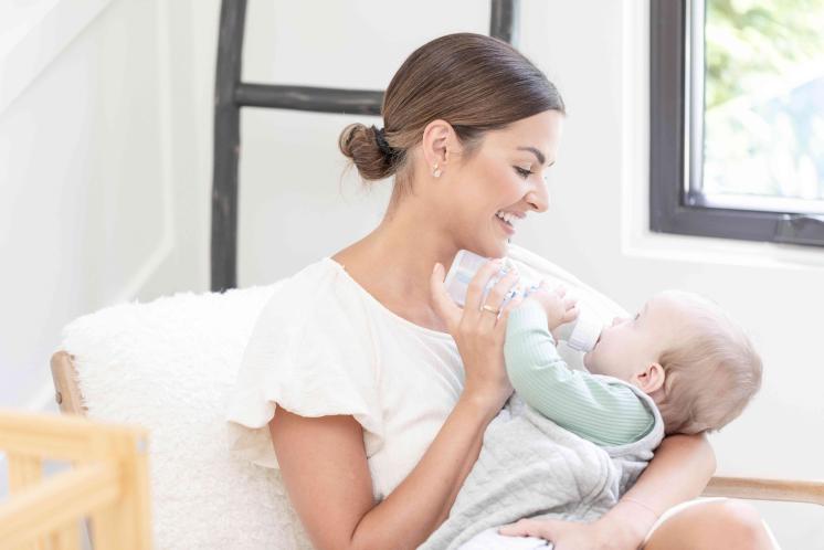 mom feeding baby bottle