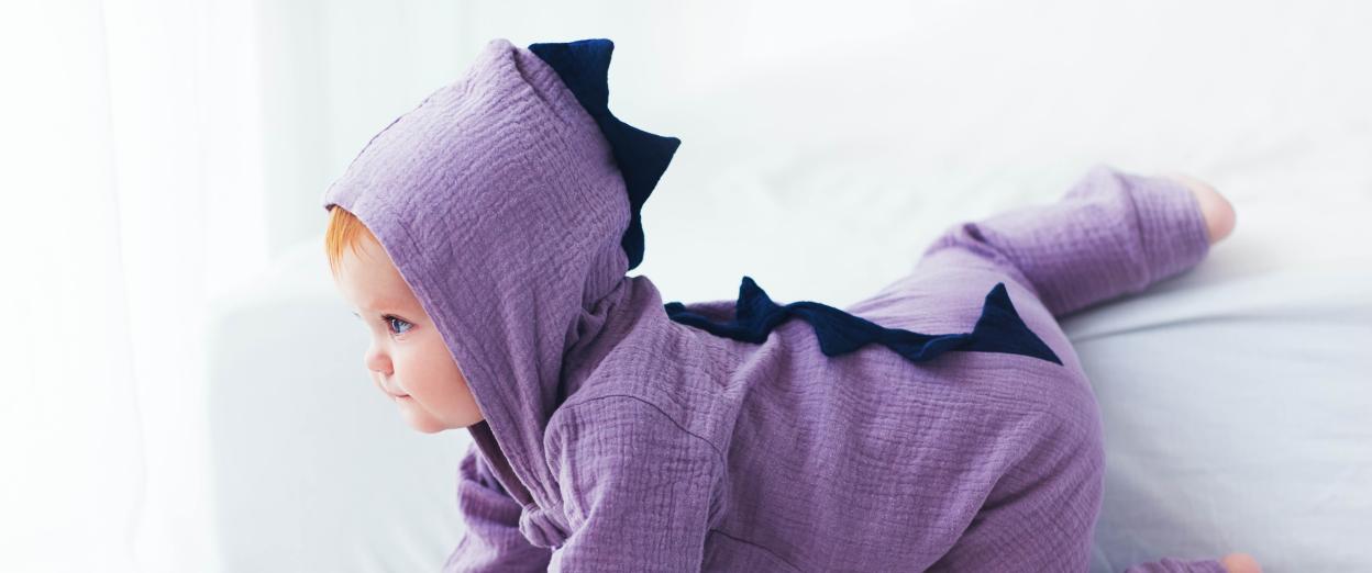 baby crawling across floor in purple monster costume