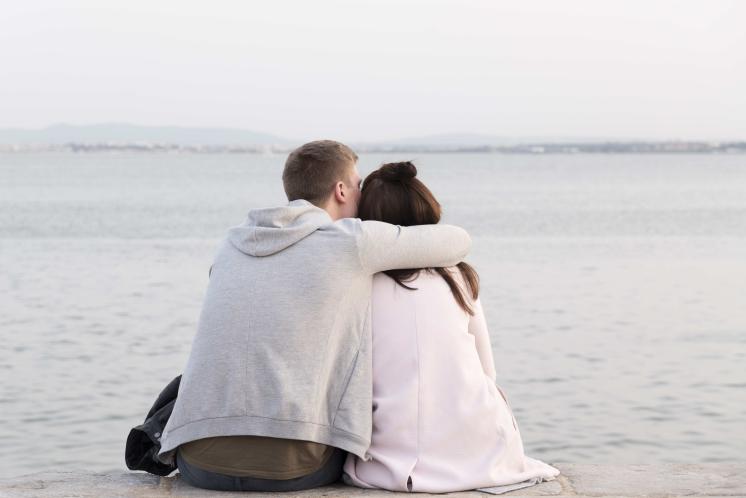 man giving a woman an caring hug facing away from the camera