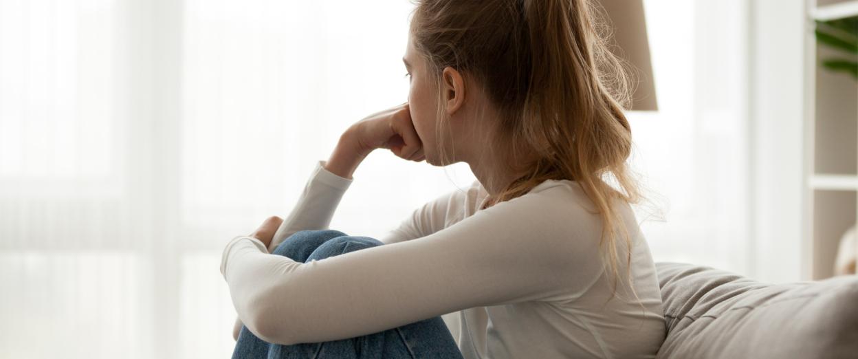 woman sitting with hand on chin and looking out the window