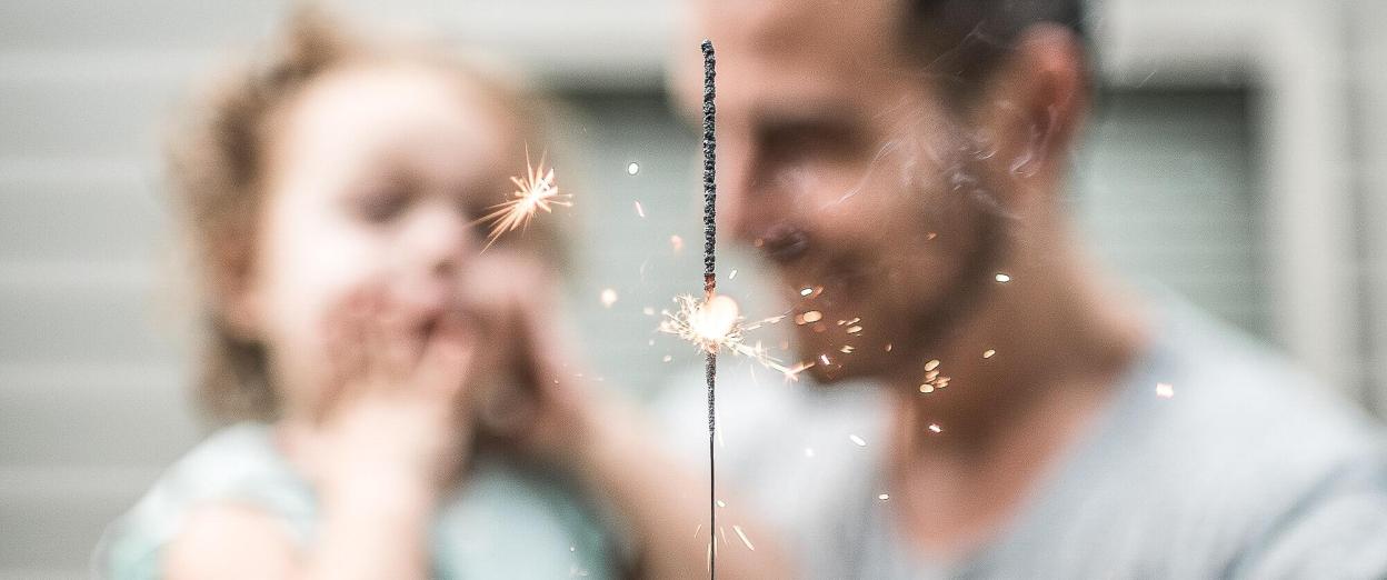 Daddy and baby looking at sparkler